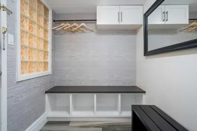 a walk in closet with a bench and a mirror at Slopeside Haven - Ski-In Ski-Out Adventure Base in Blue Mountains