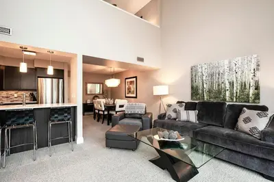 a living room with a couch and a kitchen at Hillside Lookout - Ski-In Ski-Out Alpine Escape in Blue Mountains