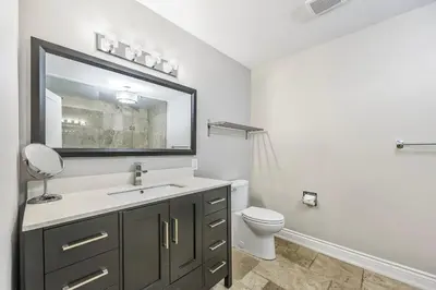 a bathroom with a sink and a toilet and a mirror at Slopeside Hideout Ski-In Ski-Out Walk to Village in Blue Mountains