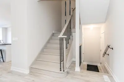 a staircase in a house with white walls at Family Townhouse Walk-Shuttle to Blue Fire Pit in Blue Mountains