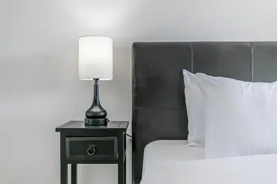 a lamp on a night stand next to a bed at Family Townhouse Walk-Shuttle to Blue Fire Pit in Blue Mountains