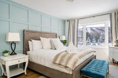 a bedroom with a bed with a blue wall at Blue Mtn Village Retreat Walk to Blue - Shuttle in Collingwood