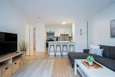 a living room with a couch and a kitchen at Cranberry Apres Nest Bright Reno Near Blue Mtn in Collingwood