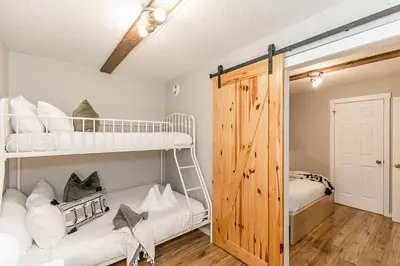 a bedroom with two bunk beds and a closet at South Wind - Modern Condo in Collingwood - Sleep 5 in Collingwood