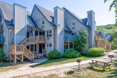 a large house with a bench in front of it at Wanderer Way Loft Ski-In Ski-Out - Pool & Hot Tub in Blue Mountains