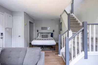 a bedroom with a bed and a stair case at Wanderer Way Loft Ski-In Ski-Out - Pool & Hot Tub in Blue Mountains