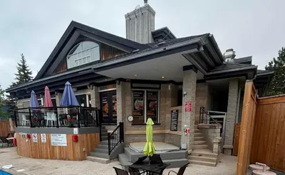 a house with a patio with umbrellas on the porch at Tranquility Oasis Ski-In Out Hot Tub Shuttle in Blue Mountains