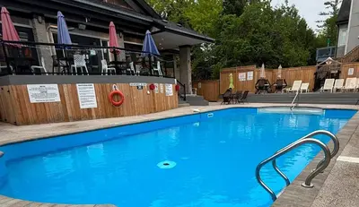 a large blue swimming pool in front of a building at Tranquility Oasis Ski-In Out Hot Tub Shuttle in Blue Mountains