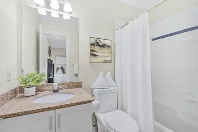 a white bathroom with a toilet and a sink at Cozy Nest Ski-In-Out Pool Hot Tub Shuttle in Blue Mountains