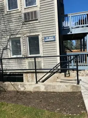 a building with a black railing in front of a building at Cozy Nest Ski-In-Out Pool Hot Tub Shuttle in Blue Mountains