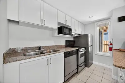 a kitchen with white cabinets and a stainless steel refrigerator at Heavenly Hideaway Ski-In-Out Pool Shuttle in Blue Mountains