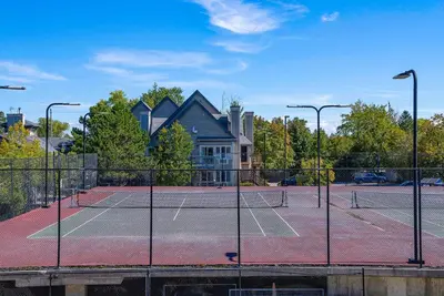 a tennis court with two tennis courts at Foxwood Retreat - Shuttle to Blue Pool & Hot Tub in Blue Mountains