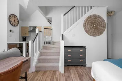 a bedroom with a staircase and a bed and a clock at Arrowhead Retreat Ski-In-Out Pool Shuttle in Blue Mountains
