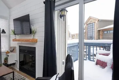 a living room with a fireplace and a screened in porch at Northern Peaks Ski In-Out Hot Tub Shuttle Access in Blue Mountains