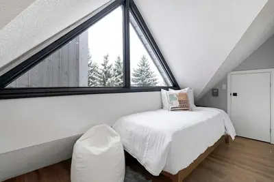a bedroom with a bed and a large window at Mountainside Escape Ski-In-Out Pool Shuttle in Blue Mountains