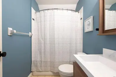 a bathroom with a shower curtain and a toilet at Mountainside Escape Ski-In-Out Pool Shuttle in Blue Mountains