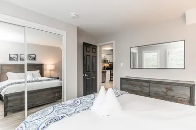 a white bedroom with two beds and a mirror at Mountain View Ski-In-Out Pool Shuttle to Blue in Blue Mountains