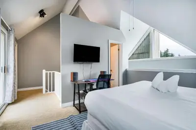a bedroom with a bed and a tv and a window at Blue Haven Ski-In-Out Pool Hot Tub Shuttle in Blue Mountains