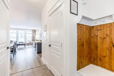 a hallway with a white door and a wooden wall at Rivergrass Oasis Across from Blue Mtn Hot Tub in Blue Mountains