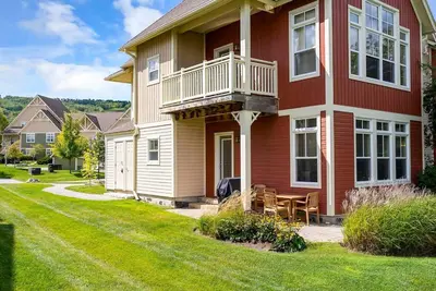a red and white house with a balcony and a lawn at Hickory Ridge Across Blue Mtn Hot Tub Shuttle in Blue Mountains