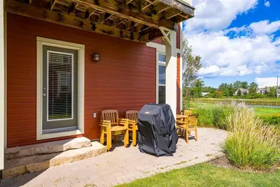 a house with a patio with chairs and a backpack on it at Hickory Ridge Across Blue Mtn Hot Tub Shuttle in Blue Mountains