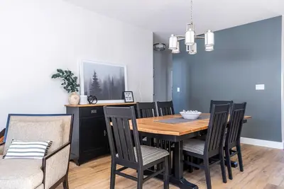 a dining room with a wooden table and chairs at Three Suns Across Blue Mtn Hot Tub & Shuttle in Blue Mountains