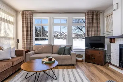 a living room with a couch and a tv at Three Suns Across Blue Mtn Hot Tub & Shuttle in Blue Mountains