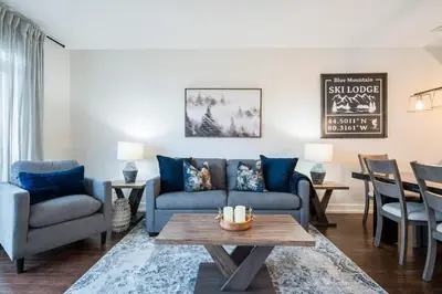 a living room with a blue couch and a table at The Blue - Walk to the Village Shuttle & Hot Tub in Blue Mountains