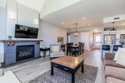 a living room with a fireplace and a table at Sunny Days - Steps to Blue Mtn - Hot Tub & Shuttle in Blue Mountains