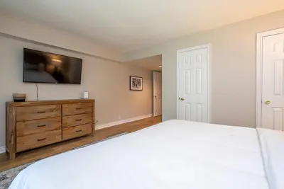 a bedroom with a bed and a dresser with a flat screen tv at Sierra Point - Walk to the Blue - Outdoor Pool in Blue Mountains