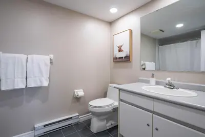 a white bathroom with a toilet and a sink at Sierra Lookout - Steps to Blue Mountain Village in Blue Mountains