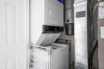 a washer and dryer in a kitchen with a microwave at Sierra Lookout - Steps to Blue Mountain Village in Blue Mountains