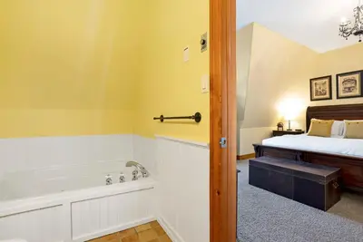 a bathroom with a bath tub and a bed at Out of the Blue - Shuttle to Blue Walk & Trails in Blue Mountains