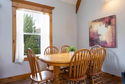 a dining room with a wooden table and chairs at Still Winds - Private Patio - Shuttle to Blue in Blue Mountains