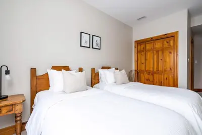 two beds sitting next to each other in a bedroom at Snowy Mountain Summit & Sol - Shuttle - Patio in Blue Mountains