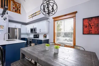 a kitchen with a wooden table and a dining room at Lookout Lodge - Private Patio - Shuttle to Blue in Blue Mountains