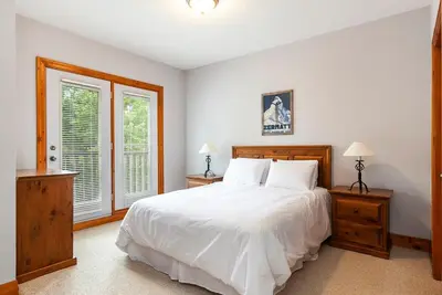 a bedroom with a white bed and two windows at Lookout Lodge - Private Patio - Shuttle to Blue in Blue Mountains