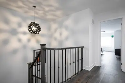 a hallway with a staircase and a chandelier at Blue Mountain Townhome - Patio Shuttle Trails in Blue Mountains