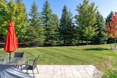 a patio with a table and a red umbrella at Luxury Mountain Townhome - Shuttle Patio & Trails in Blue Mountains