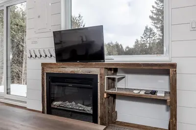 a living room with a tv and a fireplace at The Hideaway - Tiny House in Flesherton