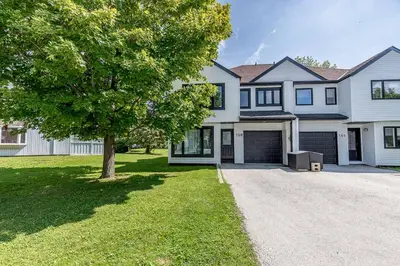 a large white house with a tree in the yard at Snow Pine - 10 minute drive to Blue in Collingwood