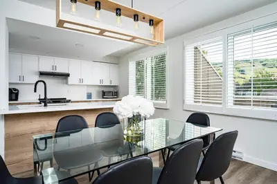 a dining room with a glass table and chairs at Apres-Blu - Walk to theVillage - Sleeps 7 in Blue Mountains