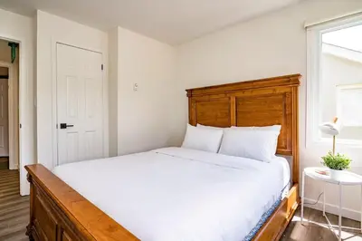 a bedroom with a large bed with a wooden headboard at Apres-Blu - Walk to theVillage - Sleeps 7 in Blue Mountains