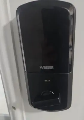 a black cell phone is sitting on a shelf at V-Swim Suite-3 in Toronto