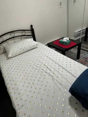 a bed with a white comforter and a table at V-Swim Suite-3 in Toronto