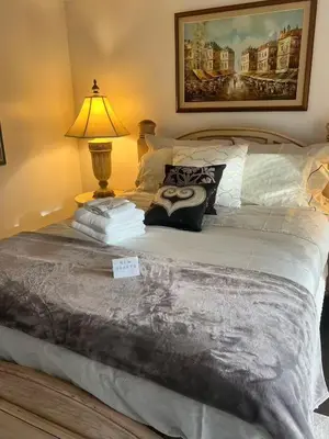 a bedroom with a bed with a lamp on it at Grimsby Lakeside Vacation Home in Grimsby