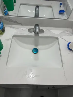 a white bathroom sink with a blue ball in it at V-Swim Suite-1 in Toronto