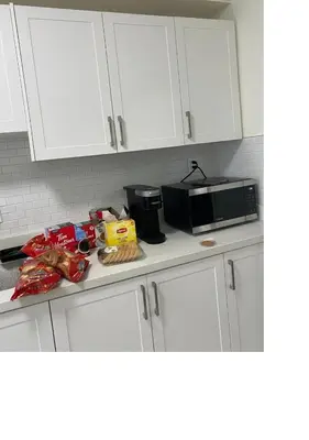 a kitchen counter with white cabinets and a microwave at V-Swim Suite-1 in Toronto