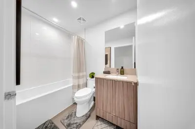 a bathroom with a toilet and a sink and a tub at The Grand Aurelia Suites - Mississauga City Center in Mississauga