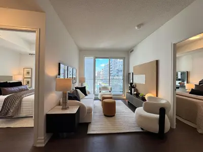 a bedroom with a bed and a large mirror at Deluxe Suites & Towers Downtown Toronto in Toronto